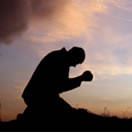 photo of a man kneeling down praying